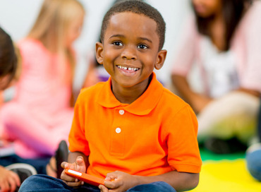 young boy in his classroom ready to learn, representing the Pre-K program