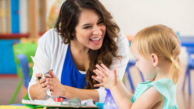 Teacher encouraging and engaging with student playing with blocks