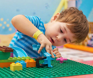 Young boy building with legos at a lego table