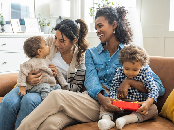 Two mothers with their children talking about daycare options 