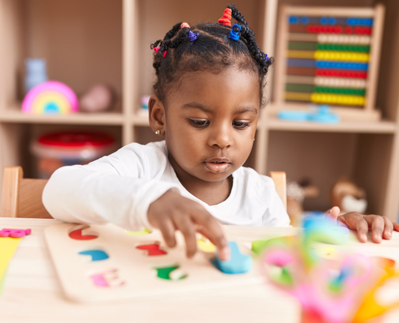 First Steps Pre-K child learns numbers by playing with a puzzle.