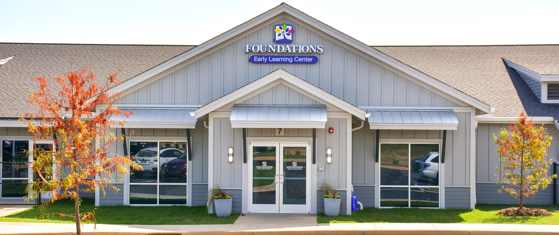 Exterior of Foundations Early Learning Center Simpsonville with board-and-batten siding, gabled entrance, and fall foliage
