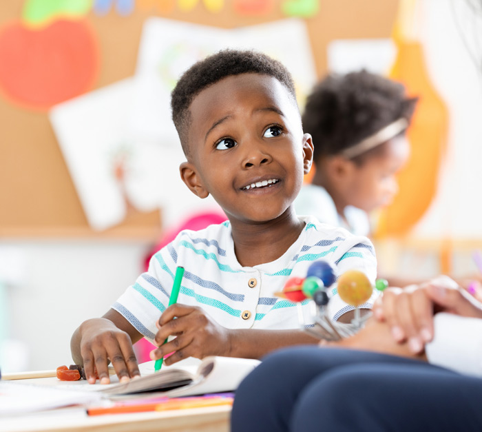 Young boy in a striped shirt doing a science activity