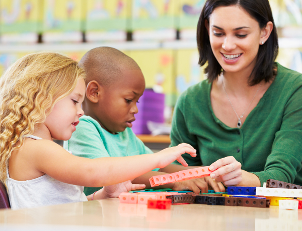 Teacher watching children build with blocks druing STEAM activity