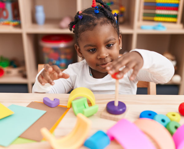 Pre-K child playing with a colorful STEAM puzzle