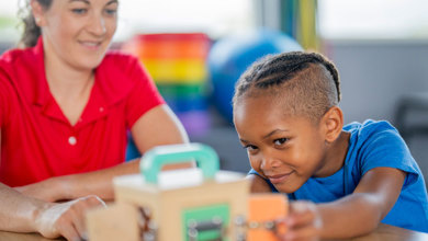Teacher with young boy working on a puzzle