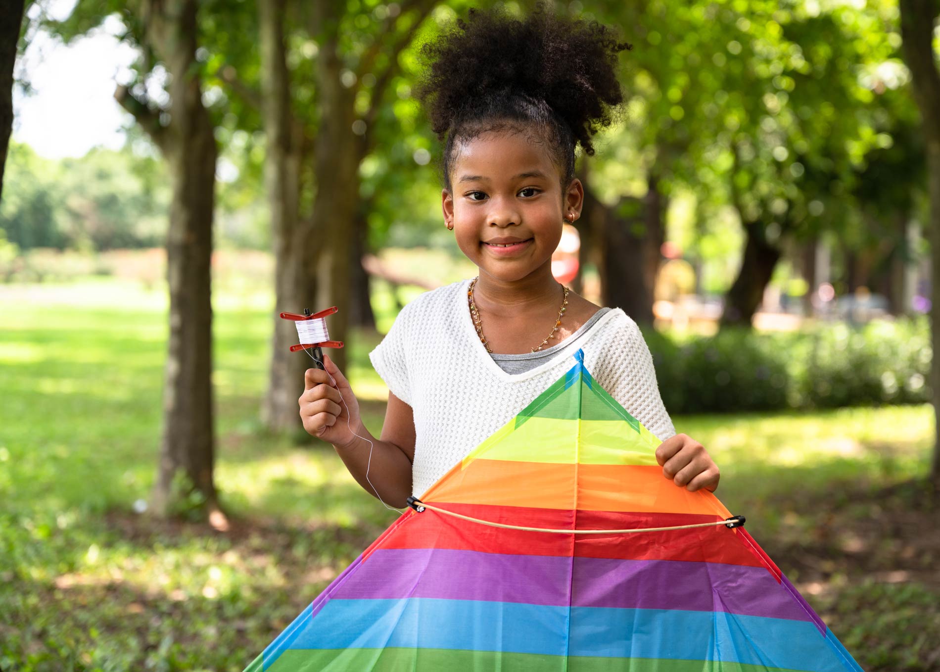 Girl outside during school break with a colorful kite