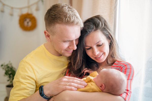 Happy couple holding their new baby
